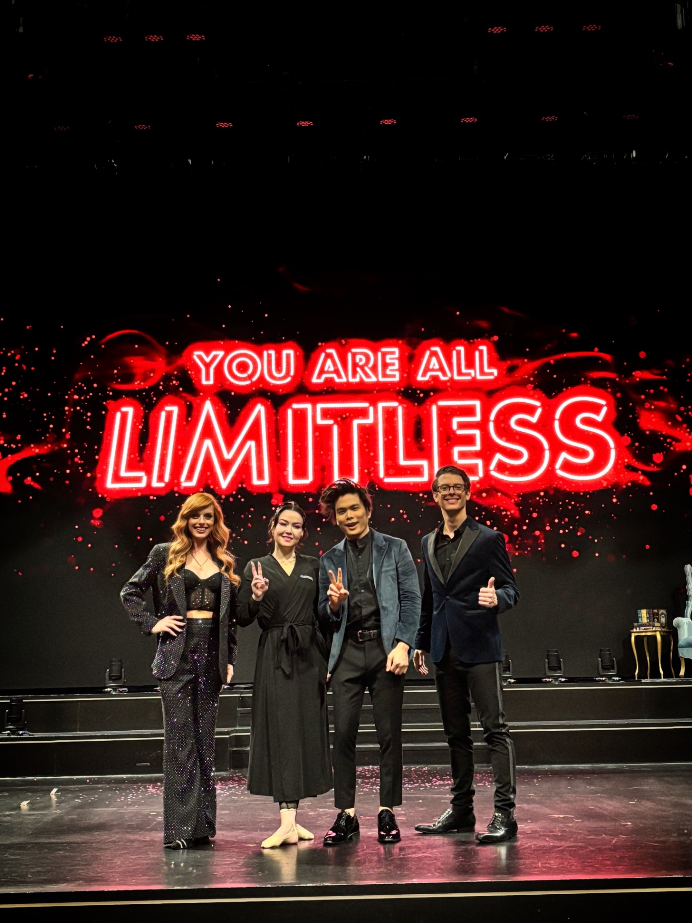 The Conjurors with fellow performers before a glowing Limitless sign
