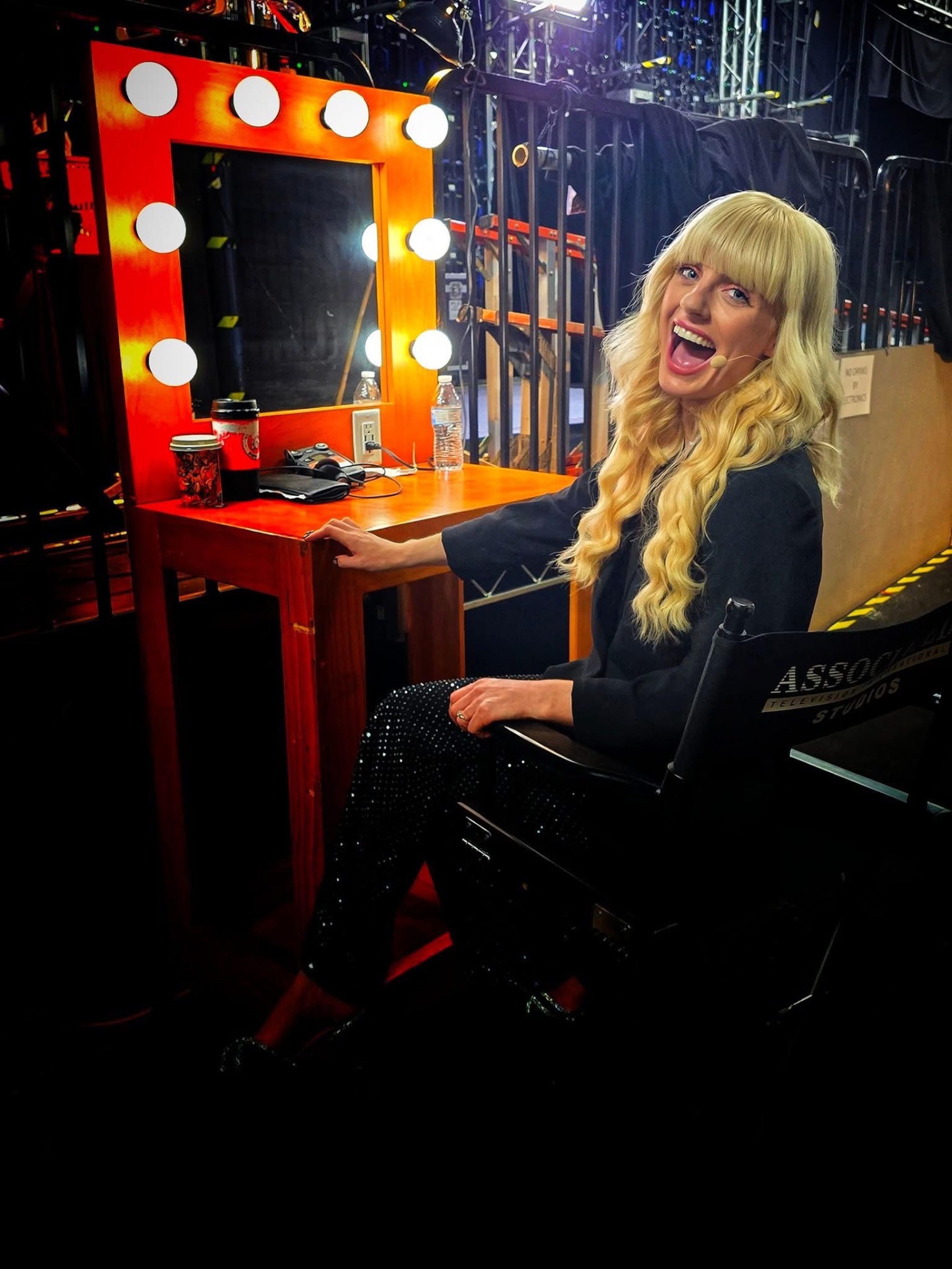 Natasha Lamb laughing backstage at a lit dressing-room mirror