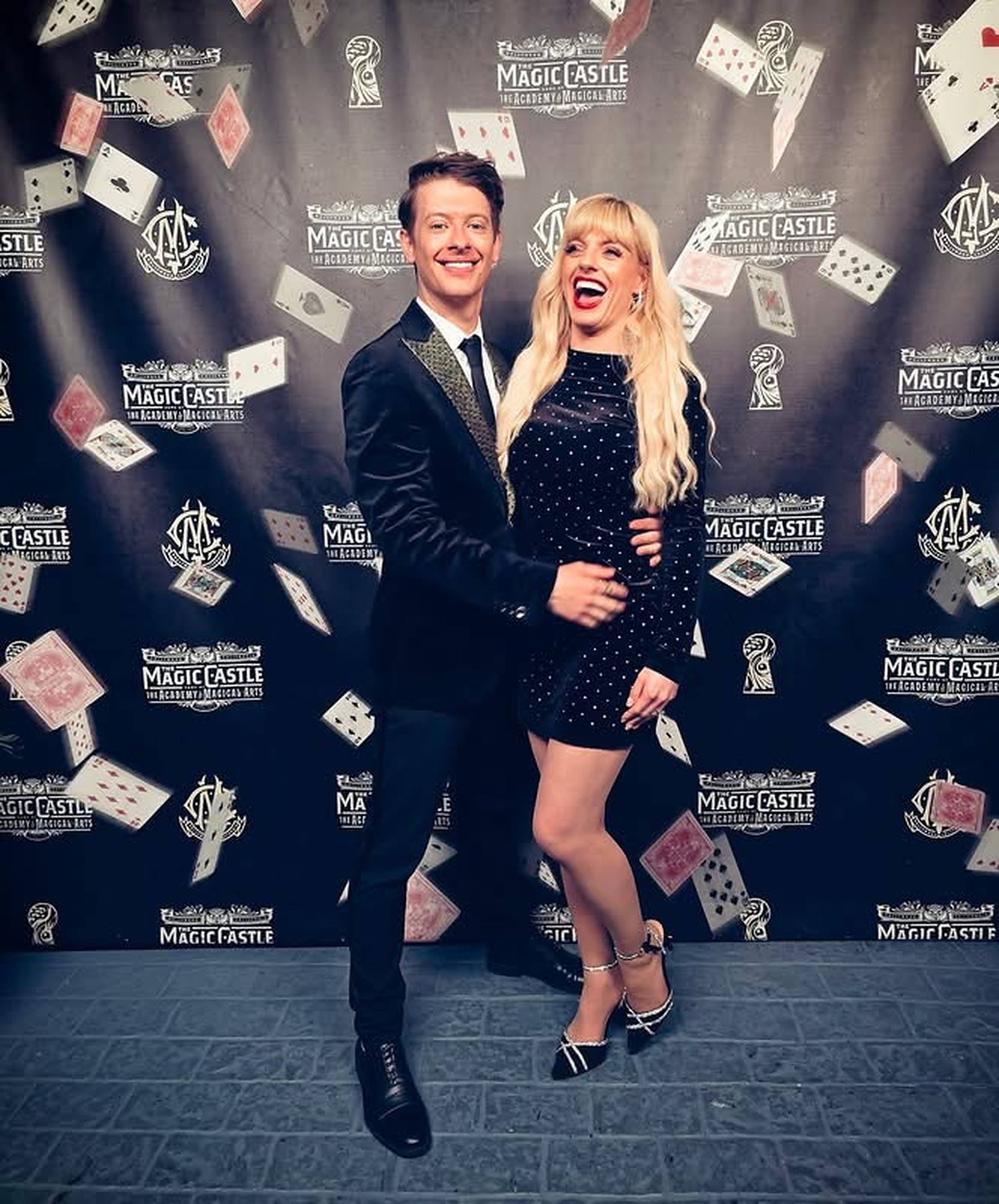 Natasha Lamb and Matthew Pomeroy posing in front of the Magic Castle backdrop wall