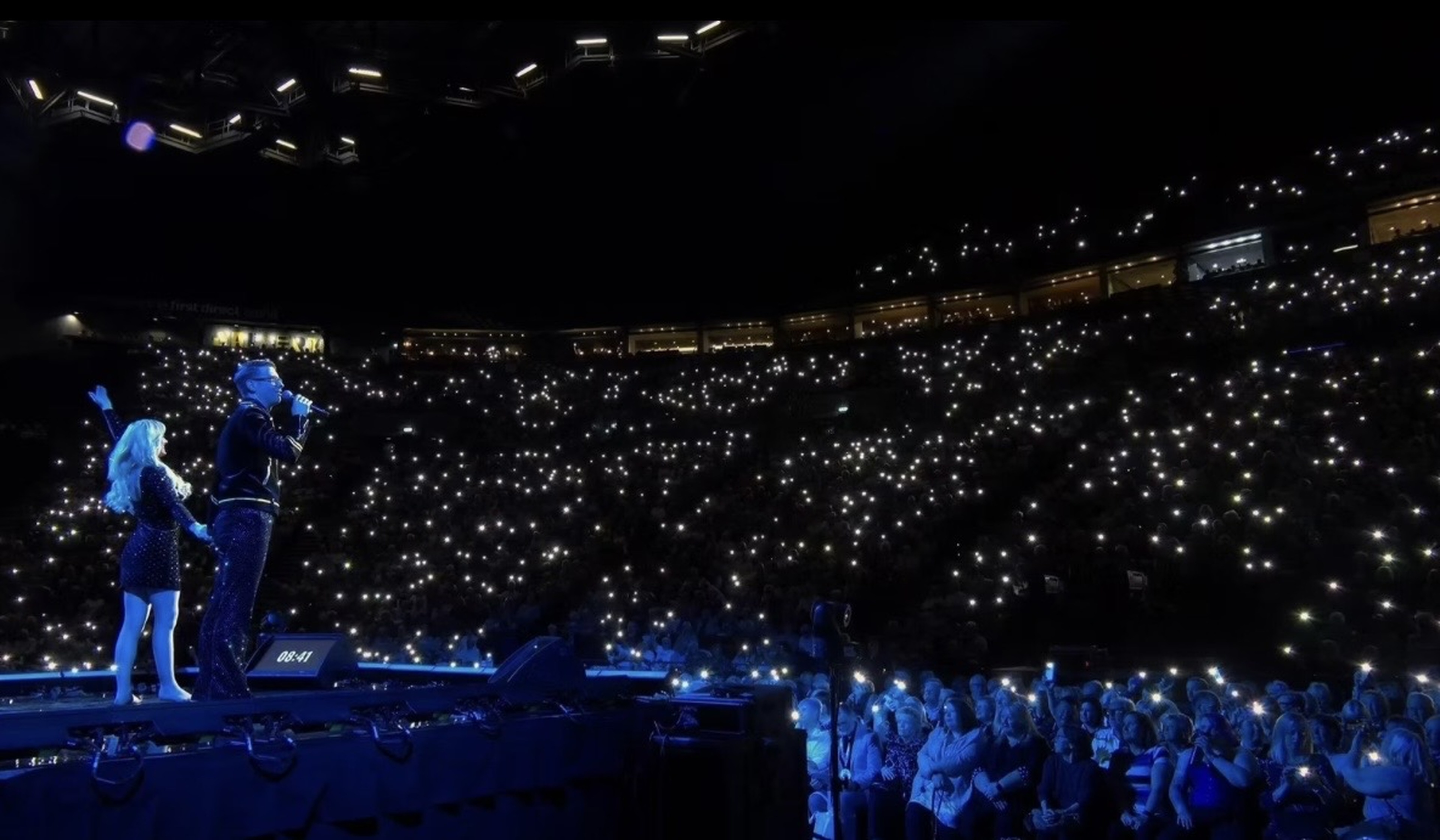 The Conjurors performing to a vast arena lit with thousands of lights