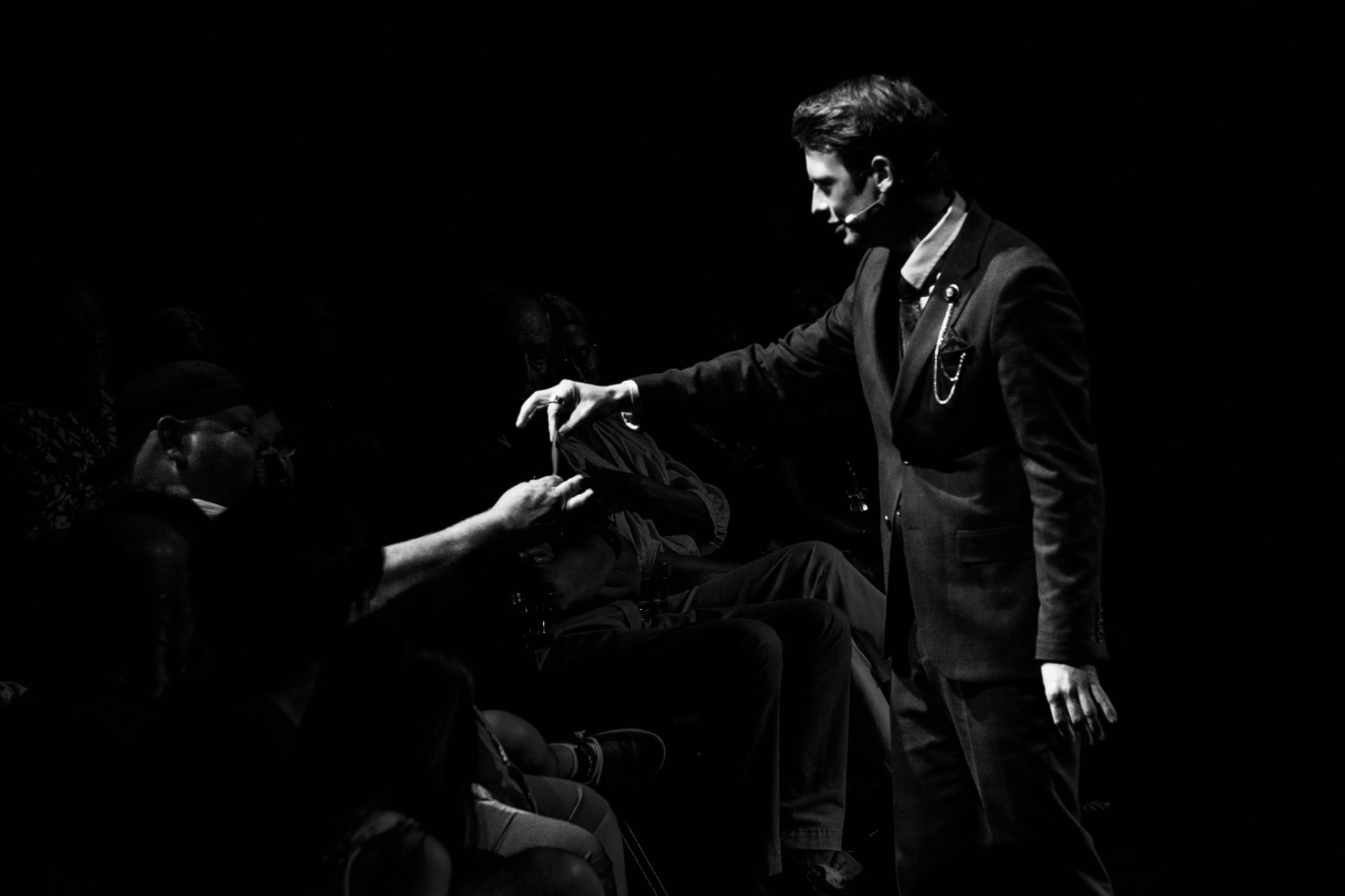 Matthew Pomeroy leaning down to a seated guest during an intimate close-up moment