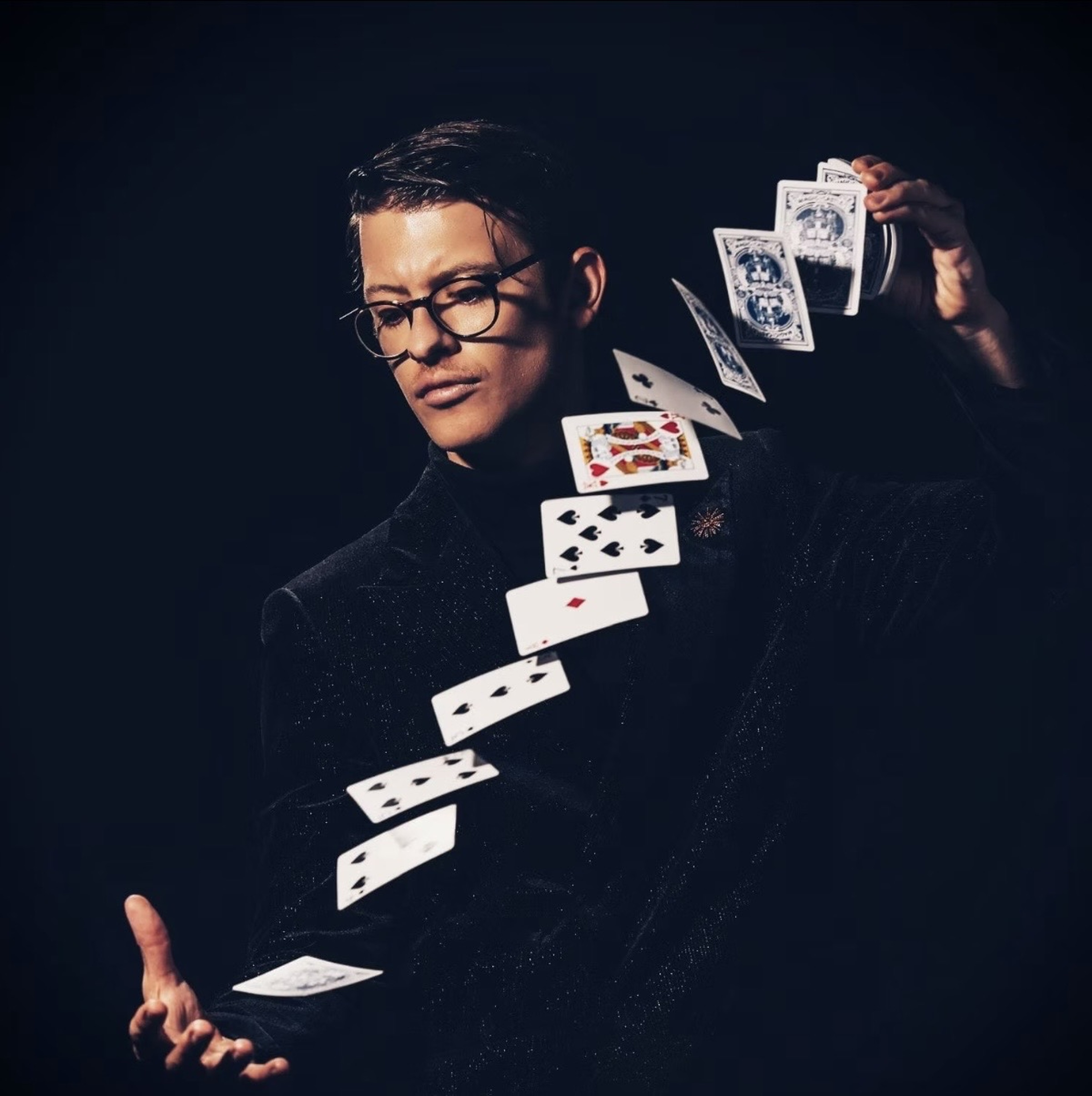 Solo portrait of Matthew Pomeroy cascading playing cards between his hands